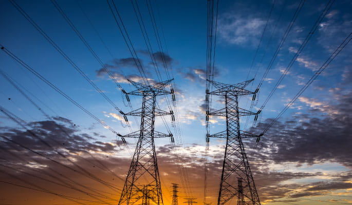 electricity pylons with a sunset behind 