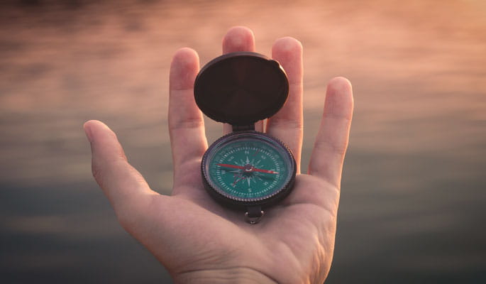 Image of a hand with an open compass in it