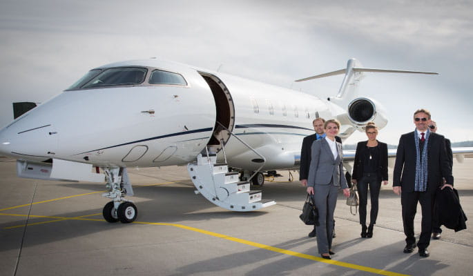 Image of business people leaving a private jet