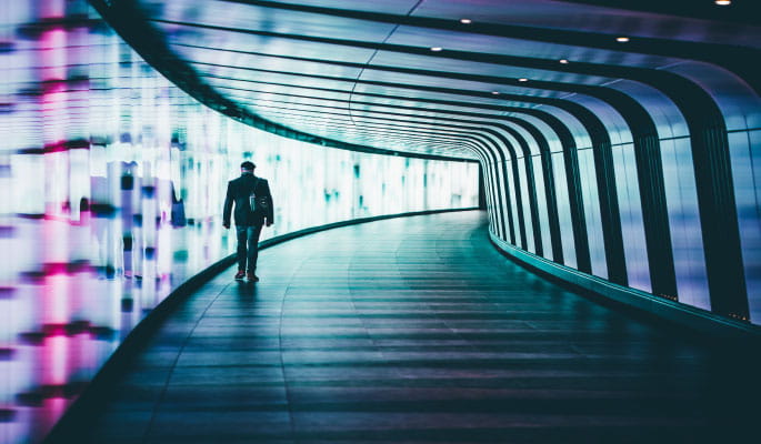 Image of a man walking through an illuminated tunnel