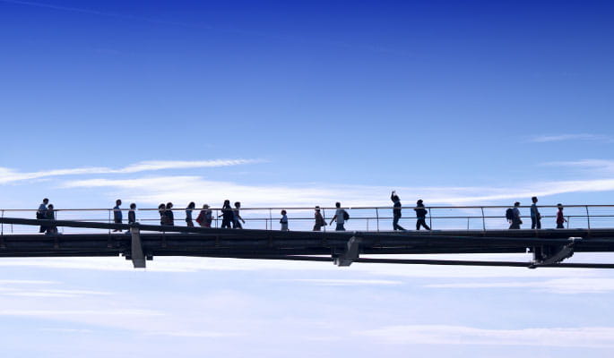 Image of people walking over a bridge 